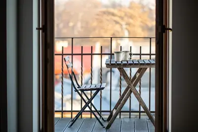 a table and a chair sitting on a balcony at Wroblewskiego No 4 Residence in Kraków
