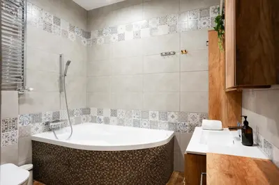 a bathroom with a tub and a sink at Wroblewskiego No 4 Residence in Kraków