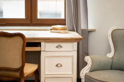 a desk with a chair and a book on it at Wroblewskiego No 4 Residence in Kraków