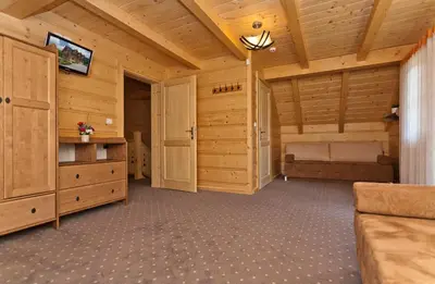 a large living room with wooden walls and a ceiling at Gorczański Domek - Koninki in Poręba Wielka