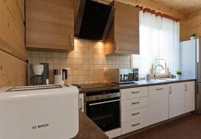 a kitchen with white cabinets and a counter top at Gorczański Domek - Koninki in Poręba Wielka