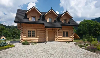 a log cabin with a black roof at Gorczański Domek - Koninki in Poręba Wielka