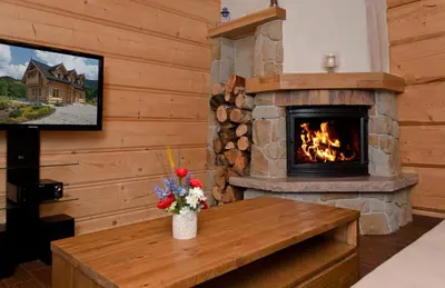 a living room with a fireplace and a tv at Gorczański Domek - Koninki in Poręba Wielka