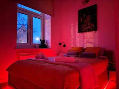a red bedroom with a large bed with red lights at Old Town Residence next to Main Station in Kraków