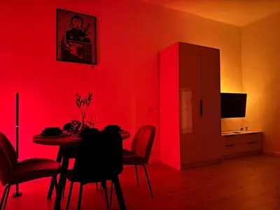 a dining room with a red wall and a table with chairs at Old Town Residence next to Main Station in Kraków