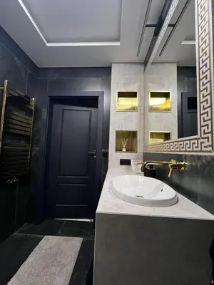 a bathroom with a sink and a black door at Apartament Wiślane Tarasy in Kraków