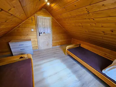 a room with a bed in a wooden cabin at Domki Mosorczyk in Zawoja