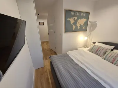 a bedroom with a bed and a flat screen tv at Wawel View 31, Kazimierz # Netflix # Air Conditioning # in Kraków