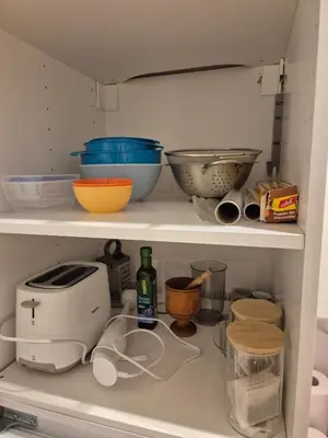 a kitchen shelf filled with bowls and other kitchen items at Wawel View 31, Kazimierz # Netflix # Air Conditioning # in Kraków