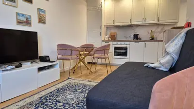 a living room with a couch and a kitchen at Wawel View 31, Kazimierz # Netflix # Air Conditioning # in Kraków