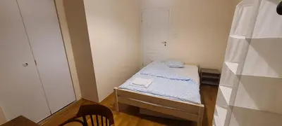 a small room with a small bed and a chair at The Augustianska Getaway in Kraków