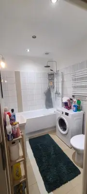 a bathroom with a washing machine and a bath tub at The Augustianska Getaway in Kraków