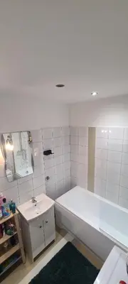 a white bathroom with a tub and a sink at The Augustianska Getaway in Kraków