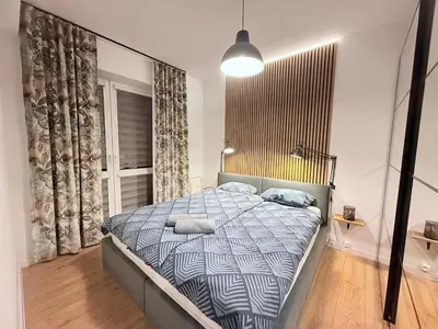 a bedroom with a bed with a blue and white comforter at Płaszowska Apartments in Kraków