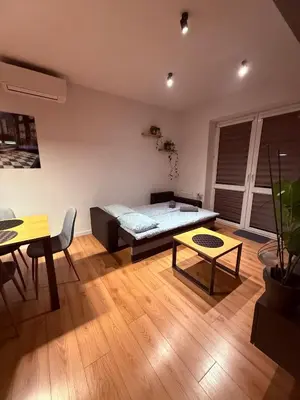 a living room with a bed and a table at Płaszowska Apartments in Kraków