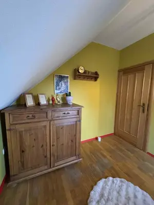an attic room with a wooden cabinet and yellow walls at Willa pod Leskowcem - agroturystyka - pokoje pod wynajem in Jaszczurowa