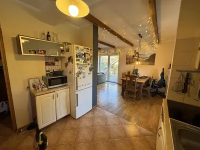 a kitchen with a white refrigerator and a table at Willa pod Leskowcem - agroturystyka - pokoje pod wynajem in Jaszczurowa