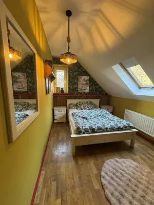 a bedroom with a bed in a attic at Willa pod Leskowcem - agroturystyka - pokoje pod wynajem in Jaszczurowa