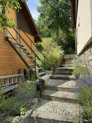 a set of stone stairs next to a building at Willa pod Leskowcem - agroturystyka - pokoje pod wynajem in Jaszczurowa