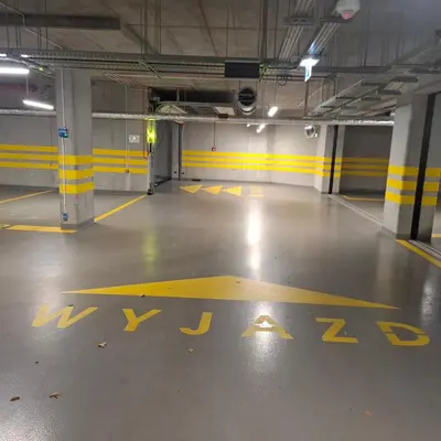 an empty parking garage with yellow markings on the floor at Krakow Apartment in Kraków