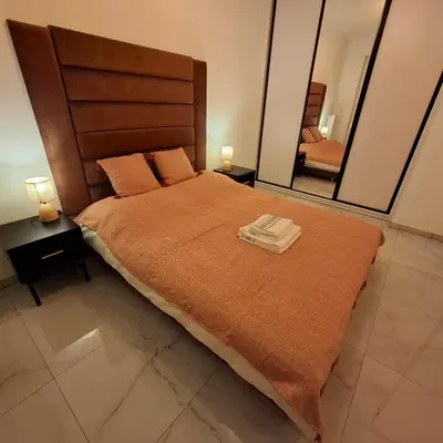 a bedroom with a large bed with two towels on it at Krakow Apartment in Kraków