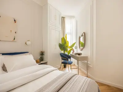 a bedroom with a bed and a desk and a mirror at Astor Residence - Fragola Apartments in Kraków