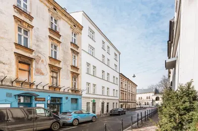 a street with cars parked in front of buildings at Astor Residence - Fragola Apartments in Kraków