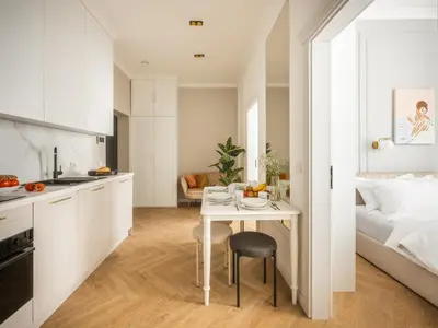 a kitchen and a bedroom with a table and a bed at Astor Residence - Fragola Apartments in Kraków