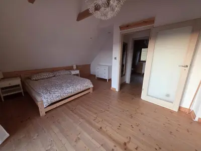 a bedroom with a bed and a wooden floor at Blejkówka in Stryszawa