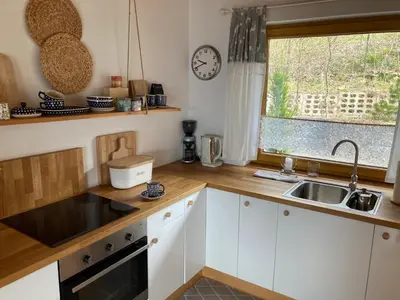 a kitchen with white cabinets and a sink and a window at Blejkówka in Stryszawa