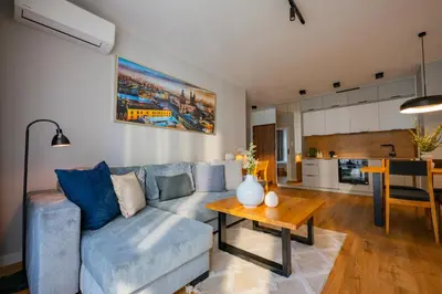 a living room with a blue couch and a table at Apartamenty w centrum Krakowa, parking w cenie in Kraków