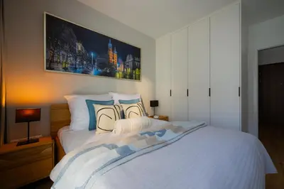 a bedroom with a large white bed with pillows at Apartamenty w centrum Krakowa, parking w cenie in Kraków