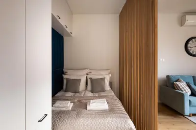 a bedroom with a bed and a blue couch at Rakowicka Suite & Parking by Downtown Apartments in Kraków