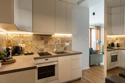 a kitchen with white cabinets and a sink at Rakowicka Suite & Parking by Downtown Apartments in Kraków