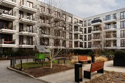 an apartment building with two benches in front of it at Rakowicka Suite & Parking by Downtown Apartments in Kraków
