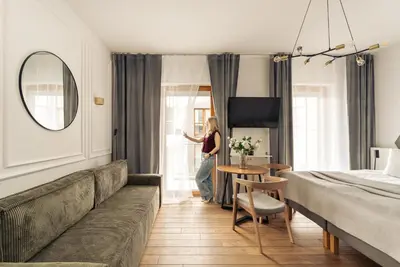 a woman standing in a hotel room looking out the window at Rakowicka Suite & Parking by Downtown Apartments in Kraków