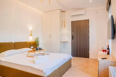 a bedroom with a large bed and a television at Strzelecka Boutique Apartments in Kraków
