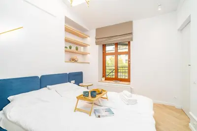 a bedroom with a blue and white bed and a table at Strzelecka Boutique Apartments in Kraków
