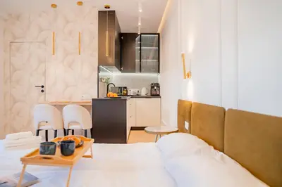 a room with a bed and a table and a kitchen at Strzelecka Boutique Apartments in Kraków