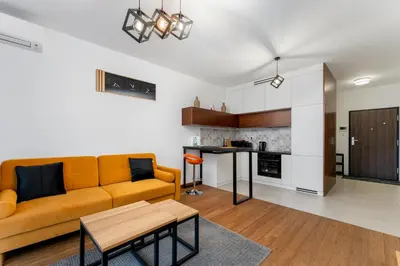a living room with a couch and a table at Wiślane Tarasy 2 0 Modern Space Studio by BookingHost in Kraków