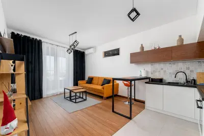 a kitchen and living room with a couch and a table at Wiślane Tarasy 2 0 Modern Space Studio by BookingHost in Kraków