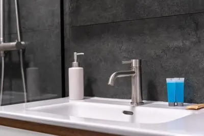 a bathroom sink with a faucet and a blue glass at Wiślane Tarasy 2 0 Modern Space Studio by BookingHost in Kraków