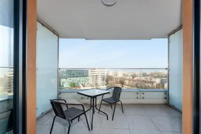 a balcony with a table and chairs and a large window at Wiślane Tarasy 2 0 Modern Space Studio by BookingHost in Kraków
