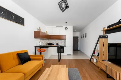 a living room with a couch and a kitchen at Wiślane Tarasy 2 0 Modern Space Studio by BookingHost in Kraków