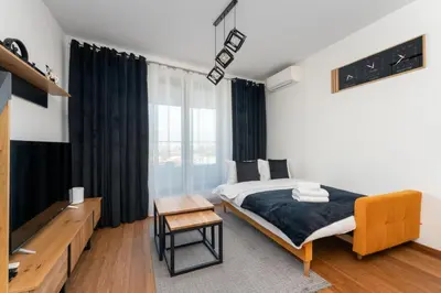 a bedroom with a bed and a tv and a table at Wiślane Tarasy 2 0 Modern Space Studio by BookingHost in Kraków