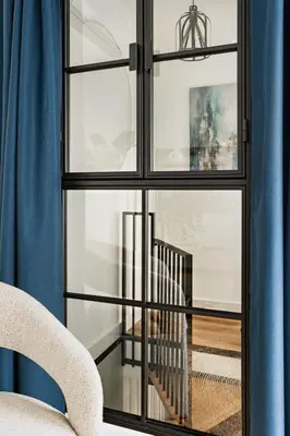 a room with a window with a chair and a staircase at Berka 12 - Quiet Two-Level Apartment in Kraków