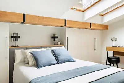 a bedroom with a large bed with blue pillows at Berka 12 - Quiet Two-Level Apartment in Kraków