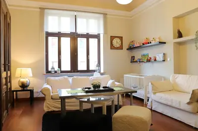 a living room with a table and a blue couch at Garncarska Old Town 120m2 4BR in Kraków