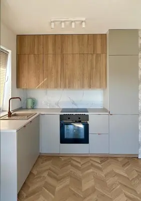 a kitchen with white appliances and wooden cabinets at Stylowe studio z tarasem in Kraków