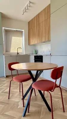 a table and two red chairs in a kitchen at Stylowe studio z tarasem in Kraków